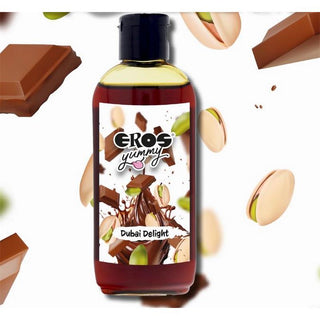 En flaska märkt EROS Dubai Delight Glidmedel 100 ml, ett vattenbaserat glidmedel, med choklad, pistagenötter och chokladbitar i bakgrunden.