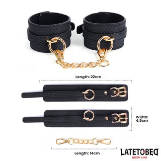 Handbojor Med Guldfärgad Kedja-svarta, strukturerade handledsfästen med guldfärgad kedja och hårdvara, med Latetobeg-logotypen. En snygg BDSM-bondageaccessoar som förhöjer din kollektion.