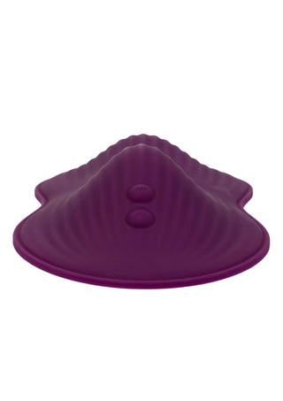 Lila vibrationsplatta av silikon med fjärrkontroll, med räfflad yta och två upphöjda knappar, sedd framifrån.