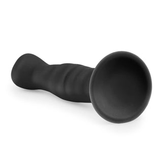 Svart analdildo i flexibelt silikon, 14 cm, med sugpropp och utvidgad bas mot vit bakgrund.