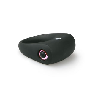 Svart silikonpenisring med rosa detaljer och avtagbar bulletvibrator, avbildad mot en vit bakgrund.
