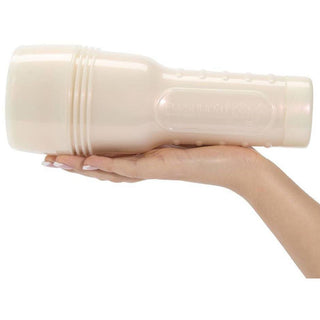 En hand håller Fleshlight Janice Griffith, en stor, beige, ficklampformad njutningsanordning tillverkad av SuperSkin-material, mot en vit bakgrund.
