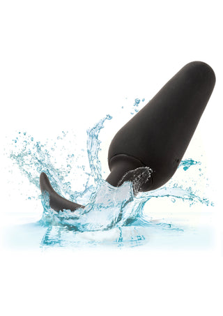 Boundless Vibrating Slim Plug i svart silikon plaskar ner i klart blått vatten, omgiven av droppar - en vattentät analplugg för njutning både under och över ytan.