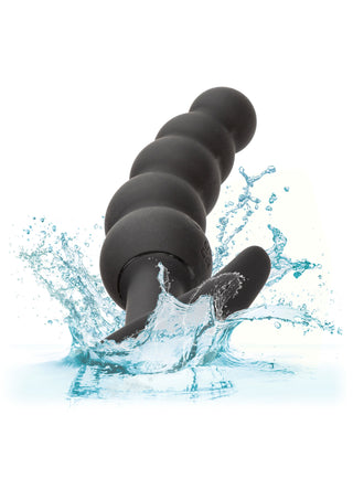 Boundless Vibrating Beaded Plug, en svart analplugg tillverkad av kroppssäker silikon, stänker i vatten när droppar sprider sig runt.