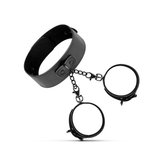 Halsband & Handledsbojor-setet är ett svart BDSM-kit i läder med justerbar krage och handledsmanschetter, sammanfogade med metallkedjor och visade mot en vit bakgrund.