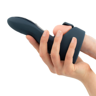 En hand håller Boners Elektrisk Masturbator, en elegant svart och beige vattentät njutningsapparat, mot en vit bakgrund - perfekt för dem som söker en elegant och funktionell leksak för vuxna.