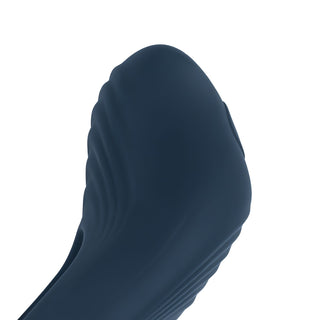 Närbild på Boners Vibrerande Penisring i mörkblått, med kroppsvänlig silikon med en slät, böjd yta och texturerade detaljer, mot en vit bakgrund.