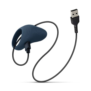 Boners Vibrerande Penisring är en mörkblå vibrerande penisring tillverkad av kroppsvänlig kisel, utrustad med en laddningsport och ansluten till en svart USB-laddningskabel.