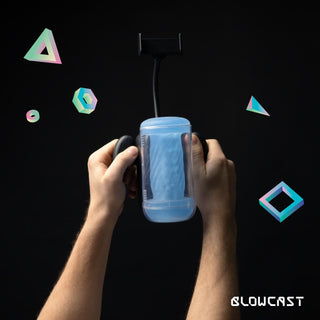 Händer som håller i Blowcast Masturbator Automatisk med telefonfäste och mjuk sleeve, omgiven av färgglada geometriska former, Blowcast-logotypen synlig.
