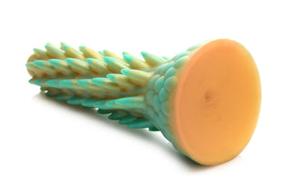 En grön och gul Stegosaurus Dildo Silikon, med texturerat silikon och en platt cirkulär bas, visas på en vit bakgrund.