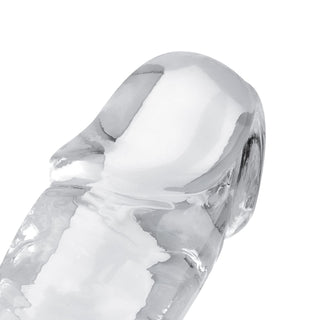 En närbild av Jelly Dildo 14 cm Utan Pung, ett klart och slätt glasliknande föremål med böjda, rundade kanter.