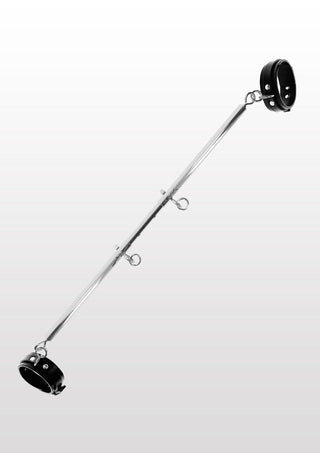 Taboom Bondage Spreader Bar med ankelmanschetter är designad för BDSM-lekar fasthållning, med justerbara öglor och svarta muddar i varje ände. Dess metallstruktur framhävs av en mjuk gradientbakgrund, vilket förstärker dess eleganta utseende.