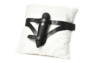XR Brands Thunder Strap, en svart strap-on-sele med en stavvibrator monterad, visas elegant på en fluffig vit kudde.