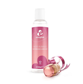 En flaska EasyGlide Rosé Glidmedel 150ml med pH-hudvänlig formula står bredvid en champagnekork dekorerad med ett rosa band.