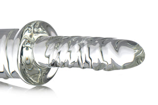En genomskinlig, räfflad dildo av borosilikatglas med en utvidgad bas, avbildad mot en vit bakgrund.