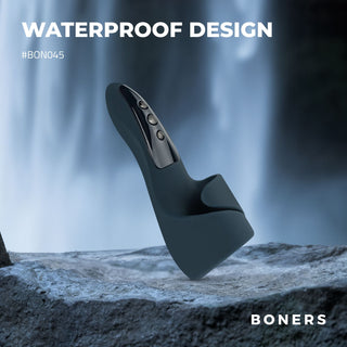 En Boners Elektrisk Masturbator, svart och vattentät, avbildad på en klippa med ett vattenfall i bakgrunden och texten "WATERPROOF DESIGN".