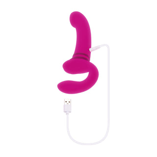 Evolved Novelties Strapless Strapon, tillverkad av kroppssäkert silikon, är en rosa vibrator med dubbla motorer och en böjd design, som visas ansluten till en vit USB-laddningskabel på en vit bakgrund.