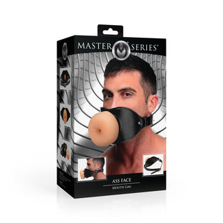 Förpackningen innehåller ett foto av en man som bär Ass Face Mun-Gag Beige - en munkavle formad som en rumpa, perfekt som en rolig BDSM-leksak för lekfulla vuxna.