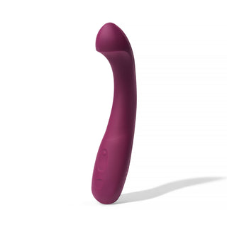 Dame Arc G-punktsvibrator i lila silikon står upprätt mot en vit bakgrund och har en böjd, rundad spets utformad för klitorisstimulering.