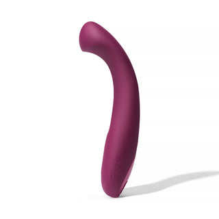 Dame Arc G-punktsvibrator är en böjd, lila silikonvibrator som står upprätt på en vit bakgrund, utformad för klitorisstimulering och är vattentät för mångsidig njutning.