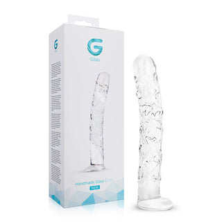 En genomskinlig dildo i texturerat glas, 19 cm, som står upprätt bredvid en vit förpackning med texten ”Handgjord glasdildo från Glädi”.