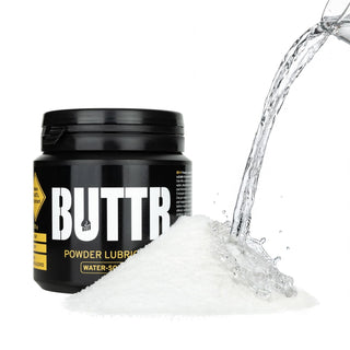 En genomskinlig plastburk märkt BUTTR Pulverglidmedel 135g, med vitt pulver inuti, med enkelt tryckt design.