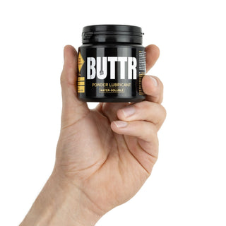 Svart plastburk märkt BUTTR Pulverglidmedel 135g, mot en vit bakgrund.