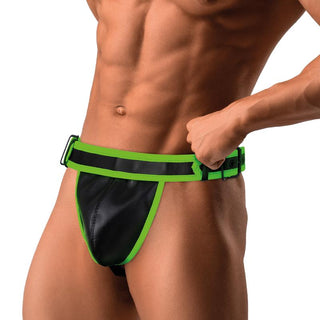 En muskulös man visar upp Shining Line Glow Jockstrap i svart och grönt veganläder från mitten av bröstkorgen till övre delen av låren.