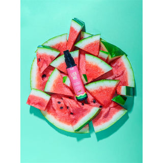 Vattenmelonskivor åtföljer en rosa Intt Lick Me Vattenmelon 50ml flaska på en mintgrön bakgrund, vilket skapar en smakrik gel vibe.