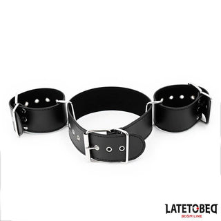 Latetobed Neck & Wrist Cuff är en fasthållningsanordning i svart läder med metallspännen, utformad för att säkra handleder och midja; med Latetobed-logotypen - idealisk för att para ihop med ett bondagehalsband eller handbojor för total underkastelse.