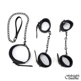 Set med fyra svarta fästremmar i veganskt läder med metallkedjor, inklusive handbojor, halsband och koppel.
