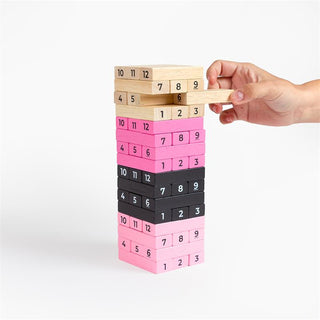 En hand drar ett träblock från Erotiskt Jenga Spel för Par, ett färgglatt tornspel som ger spänning till din spelkväll.