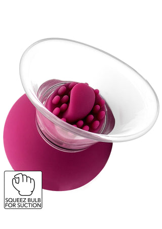 Klitorisstimulator i rosa silikon med strukturerade bulor och en transparent kant utformad för sugning.