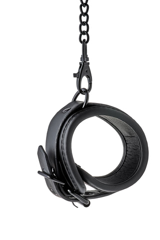 Ankelmanschetter i svart läder och neopren med justerbara spännen, sammanlänkade med en kedja och metallspänne.