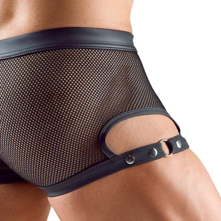 En närbild visar någon som bär "Herrboxer i Svart Mesh", med läderdetaljer och sidoband. Den eleganta designen inkluderar justerbara lårremmar med bältesliknande accenter, fästa med metallringar och tryckknappar.