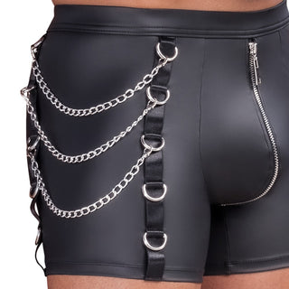 Person som bär NEK Pants Matt Svart-svarta shorts i läderimitation med blixtlås, metallkedjor, D-ringar på sidorna och en snygg cargo-ficka med dragkedja för extra edge.