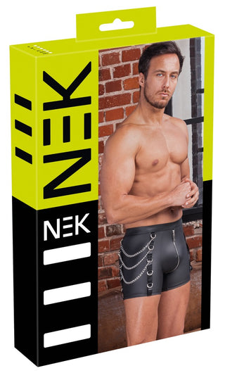 En man med bar överkropp visar upp NEK Pants Matt Svart - åtsittande svarta byxor med kedjor - utformade som shorts på en förpackning märkt NEK i gult och svart.