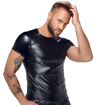 En man med skägg, klädd i en "Matt Glänsande Powerwetlook Skjorta", visar sina tatueringar samtidigt som han rör vid hans hår och blickar framåt. Skjortans glittrande omskinnsdesign framhäver dess perfekta passform.
