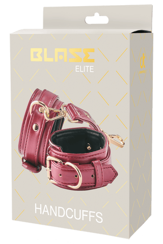 En låda med Röd Blaze Elite Handbojor-handbojor med gulddetaljer och justerbar storlek för perfekt passform.