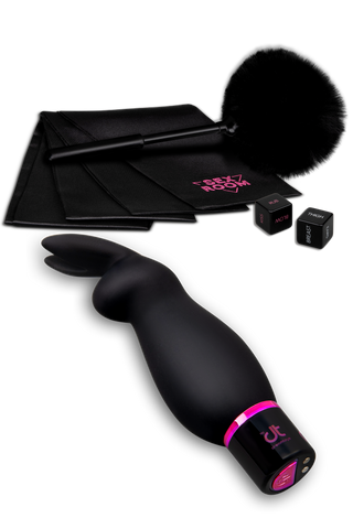 Sex Room Raunchy Vibe Set innehåller en svart kaninörsvibrator, fjäderkittlare, satinbojor och två sensuella tärningar - allt som en nybörjare behöver för spänning, snyggt arrangerat på en vit bakgrund.