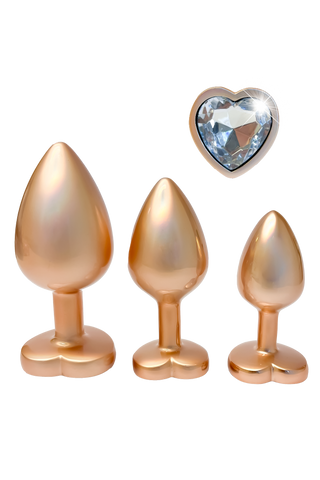 Pärlguld Buttplug Set 3-pack innehåller tre eleganta buttpluggar i aluminium med hjärtformade baser och gnistrande blå juveler, som visas på en vit bakgrund.