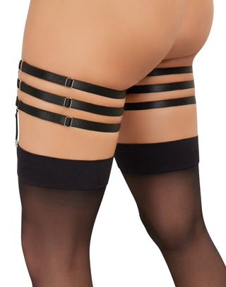 Person iklädd Glittrande Strass Strumpeband trippelstrumpeband med svarta lårband och skira svarta strumpor.