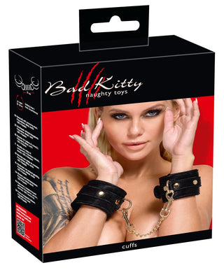 En kvinna bär Bad Kitty Black Handcuffs i svart sammet med en guldkedja, som visas på förpackningen.