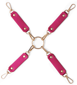 Luxury Pearl Bondage Kit har fyra rosa läderremmar i imitation med guldklämmor arrangerade i ett X runt en central guldring, vilket skapar en elegant fasthållningsuppsättning för äventyrlig lek.