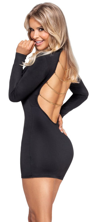 Hon ler över axeln och förbluffar i Svart Mini Dress Med Kedjor, med långa ärmar, en rygglös design och eleganta guldkedjor.