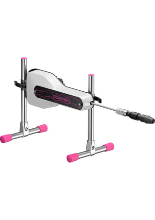 Automatisk sexmaskin i silver och rosa med svart tillbehör, dubbla stativ i metall och fötter med rosa hättor.