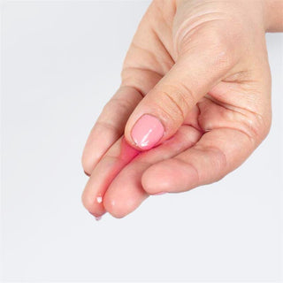 Secret Play 2 i 1 Körsbär 50 ml, en genomskinlig gel, som visas mellan två fingrar.