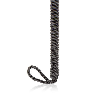 En Svart Fjäderkittlare 25 cm är sensuellt arrangerad mot en vit bakgrund, dess eleganta svarta form lindad med ena änden bildar en delikat ögla.