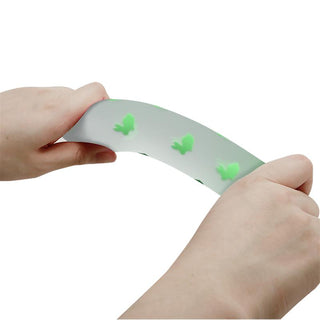 Dildo i självlysande silikon med små gröna djurformade bulor inbäddade längs ytan.