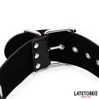 Närbild av Latetobed Neck & Wrist Cuff - BDSM-design i svart läder med metallspänne och nitar. Detta bondagehalsband ger elegans till din samling.